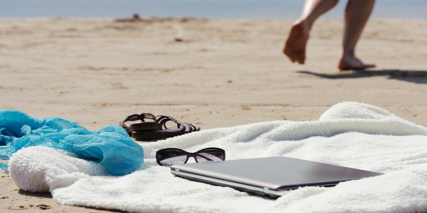 Frau mit Laptop am Strand