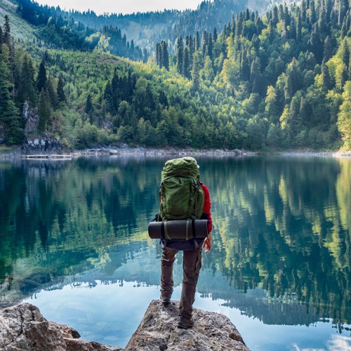 Tourist mit Rucksack am Bergsee