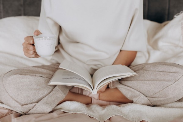 Frau liest ein Buch bei einem Tasse Tee